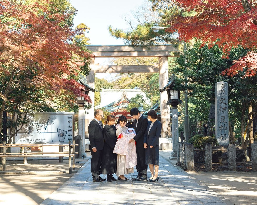 Family portrait with a baby at a traditional shrine, surrounded by vibrant autumn leaves, capturing a joyful moment. 家庭攝影,寶寶在傳統神社前,四周環繞著色彩斑斕的秋葉,捕捉愉悅的瞬間。