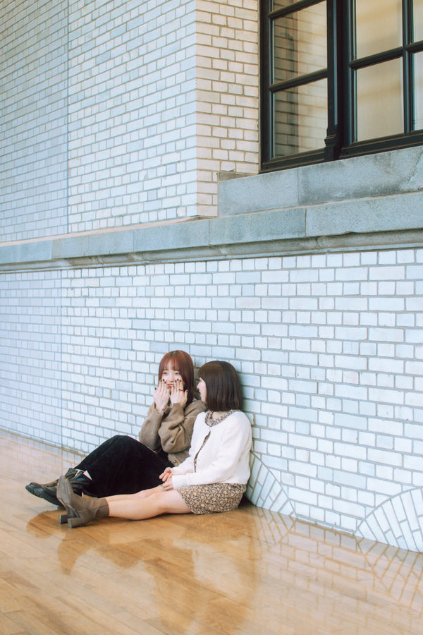 Spontaneous moment capturing two best friends engaged in lively conversation while seated casually on the floor in Fukuoka. 在福岡，捕捉到兩個最好的朋友坐在地板上，輕鬆交談的自然瞬間。 Travel photography in Fukuoka, Japan. 日本福岡的旅遊攝影。